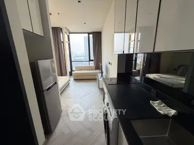 Modern apartment interior with sleek kitchen and cozy living area, featuring large windows with city view.