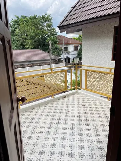Charming balcony with intricate railing and patterned tile flooring, offering a cozy outdoor space.