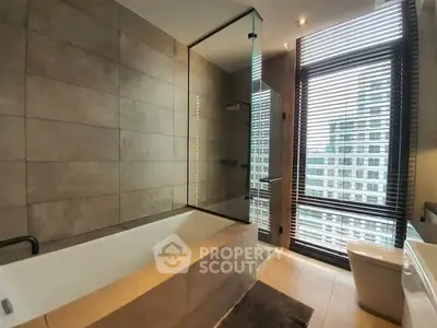 Luxurious bathroom with modern design and city view, featuring a sleek bathtub and large window.