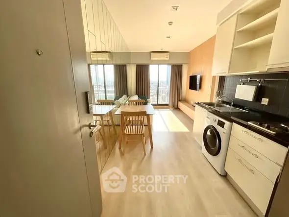 Modern open-plan kitchen and living area with natural light and city view.