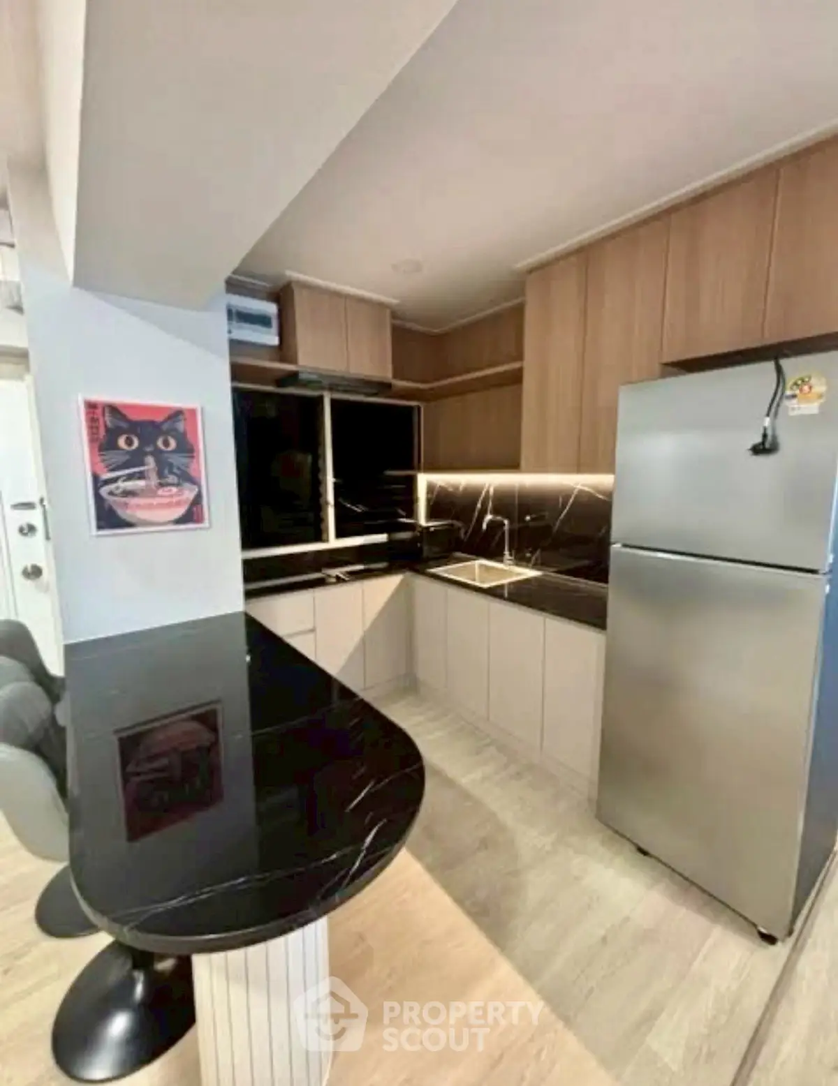 Modern kitchen with sleek black countertops and stainless steel fridge