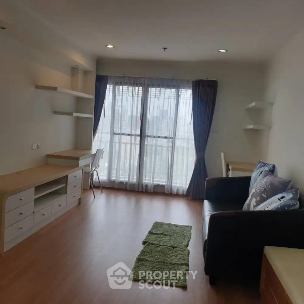 Spacious living room with modern furniture and large windows offering city views