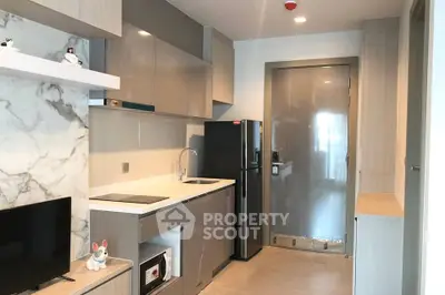 Modern compact kitchen with sleek cabinetry and integrated appliances in a stylish apartment.