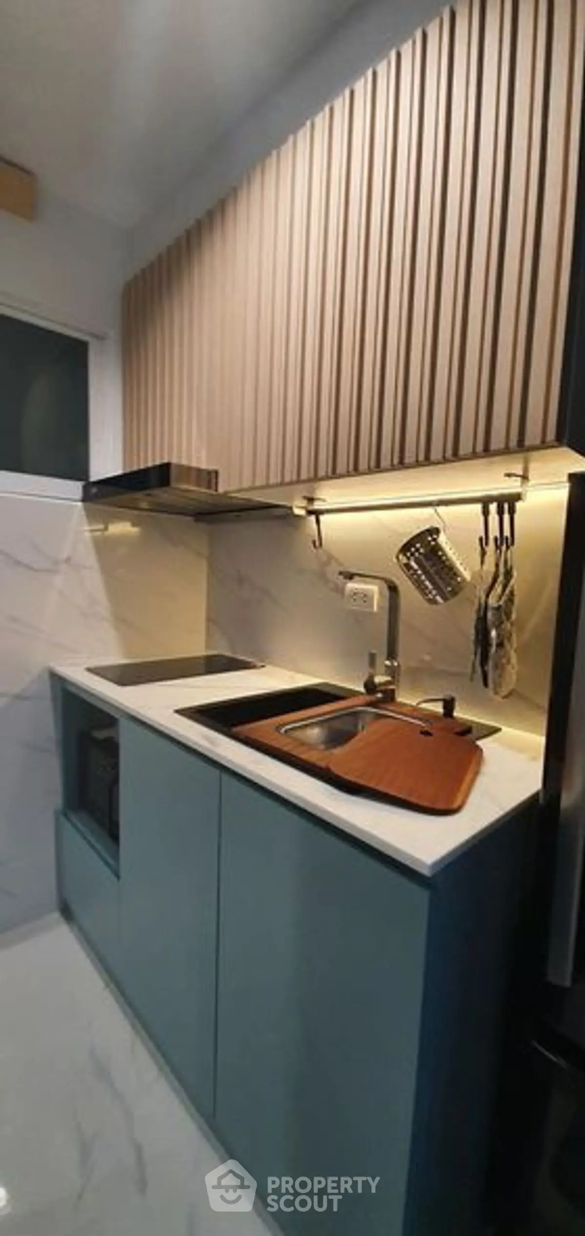 Modern compact kitchen with sleek cabinetry and marble backsplash