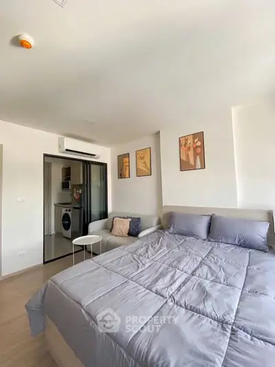 Modern bedroom with cozy decor and in-unit laundry facility