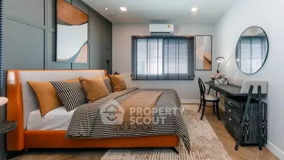 Stylish bedroom with modern decor, featuring a cozy bed, elegant desk, and chic wall art.