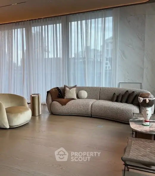 Luxurious modern living room with elegant furniture and large windows offering city views.