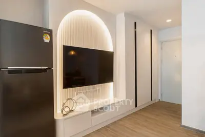 Modern interior with sleek TV setup and stylish fridge in a contemporary apartment.