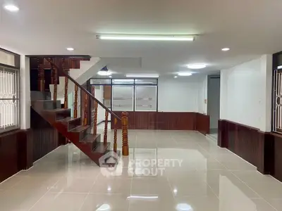 Spacious modern living room with elegant staircase and glossy tiled floors