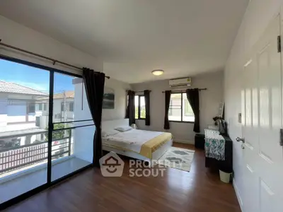 Spacious bedroom with balcony and large windows in modern home