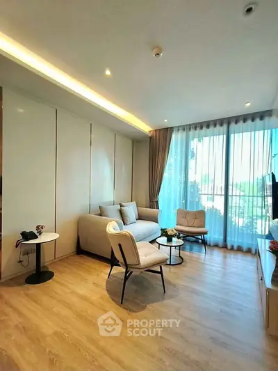 Modern living room with large windows and stylish furniture, offering a bright and inviting atmosphere.