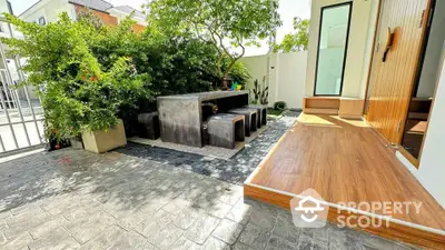 Charming outdoor patio with modern seating and lush greenery, perfect for relaxation and entertaining.