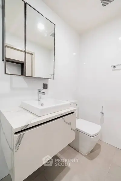 Modern minimalist bathroom with sleek fixtures and marble vanity in a bright, clean space.