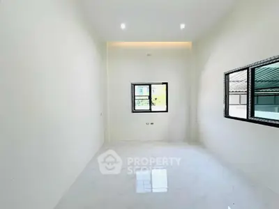Spacious and bright empty room with large windows and glossy white flooring, perfect for customization.