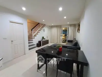 Modern living room with sleek dining area and staircase in stylish home
