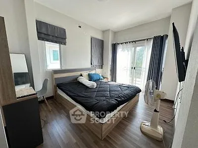 Spacious bedroom with modern decor and balcony access in a stylish apartment.