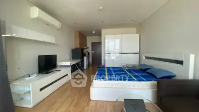 Modern studio apartment with sleek furnishings and wooden flooring