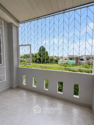 Spacious balcony with scenic view and secure railing in modern apartment.