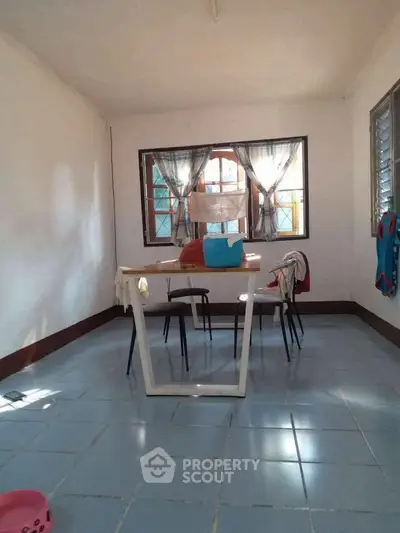 Bright dining area with large windows and modern table, perfect for family gatherings.