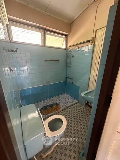 Charming vintage bathroom with blue tiles and retro fixtures, perfect for a nostalgic renovation project.