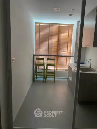 Compact kitchen with closed layout and modern design, featuring sleek cabinetry and natural light.