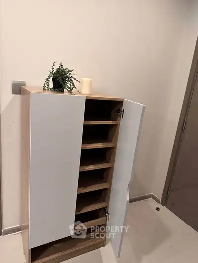 Modern storage cabinet with open shelves in a minimalist interior space.
