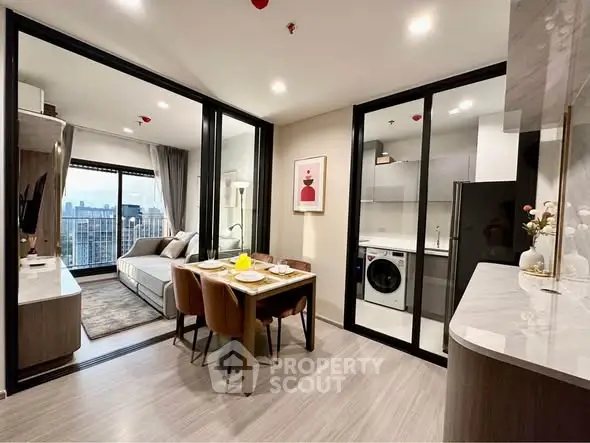 Modern open-plan apartment with city view, featuring sleek kitchen and cozy dining area.