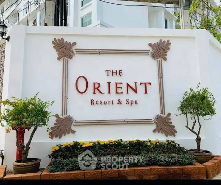 Elegant entrance sign of The Orient Resort & Spa with lush greenery.