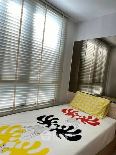 Cozy bedroom with modern decor and large windows with blinds.