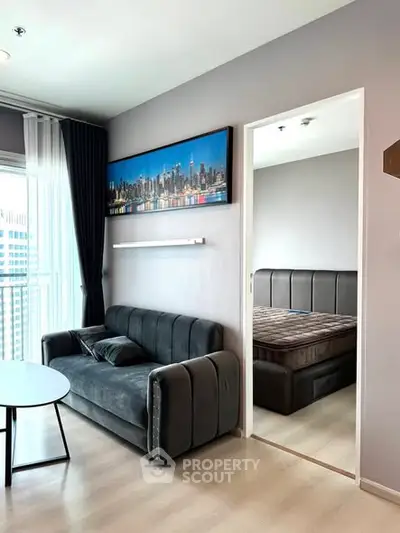 Modern living room with sleek sofa and cityscape artwork, adjacent to cozy bedroom.