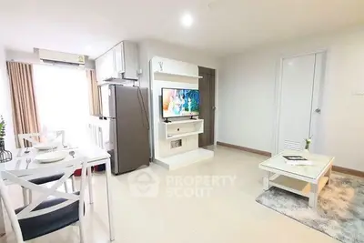 Modern living room with dining area and sleek kitchen appliances in a bright, open-concept apartment.