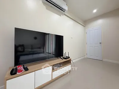 Modern living room with sleek TV setup and air conditioning