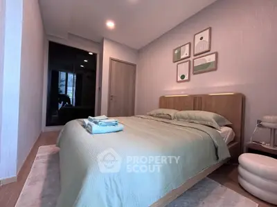 Modern bedroom with stylish decor and cozy ambiance, featuring a neatly made bed and contemporary artwork.