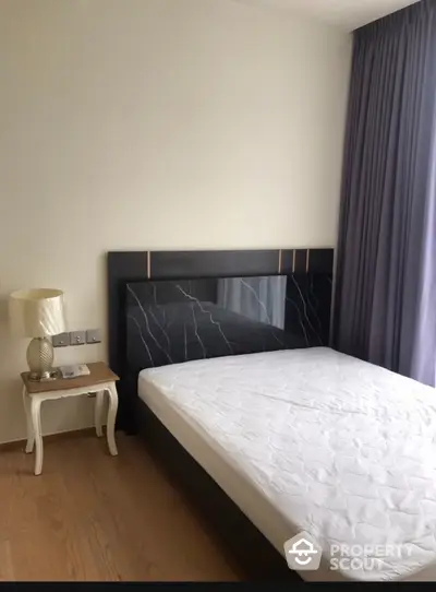 Modern bedroom with stylish bed and elegant side table in a bright apartment.