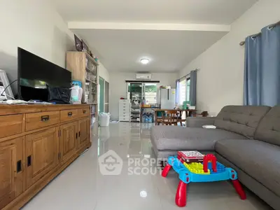 Spacious living room with modern furniture and children's play area, perfect for family gatherings.
