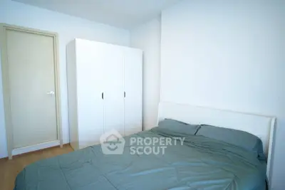 Spacious bedroom with minimalist design and ample storage in modern apartment.