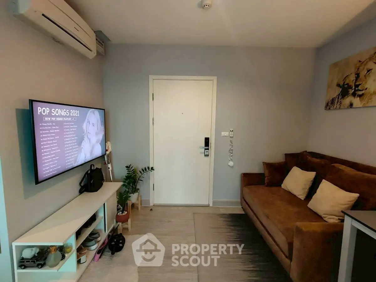 Cozy living room with modern decor, wall-mounted TV, and plush sofa
