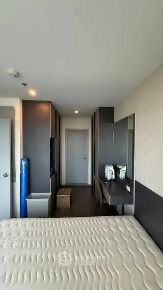 Modern bedroom with sleek design and ample storage in a high-rise apartment.