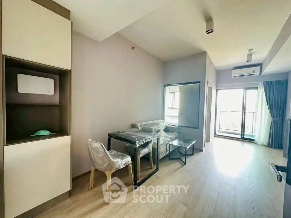 Modern living room with dining area and balcony access in a stylish apartment.