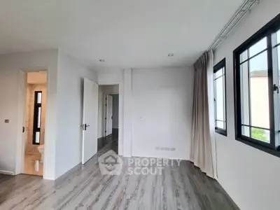 Spacious bedroom with modern flooring and large windows for natural light