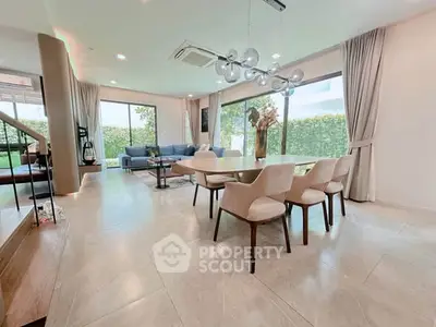 Spacious modern living room with elegant dining area and large windows overlooking garden.