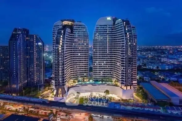 Stunning night view of modern high-rise buildings with cityscape backdrop.