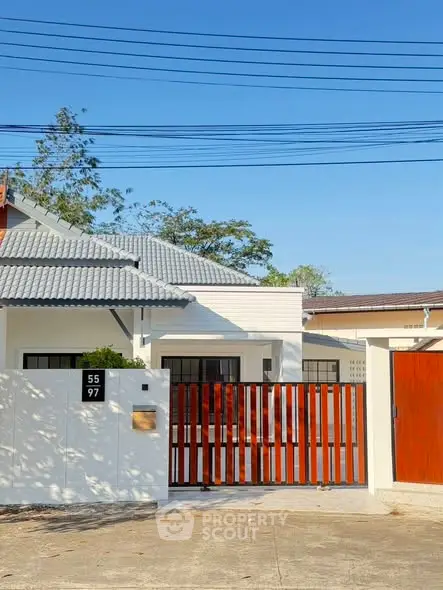 Charming suburban home with modern fence and lush greenery