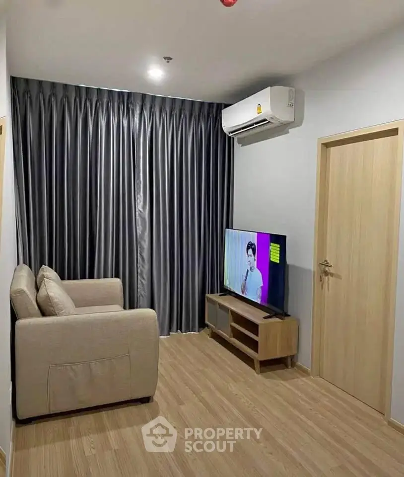 Cozy living room with modern decor, featuring a comfortable sofa and flat-screen TV, perfect for relaxation.