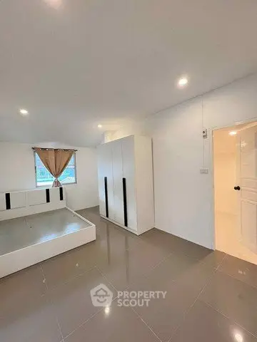 Spacious bedroom with modern wardrobe and sleek tile flooring