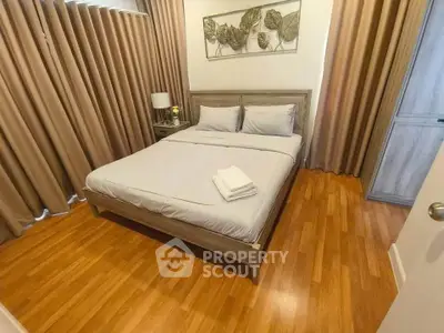 Cozy bedroom with wooden flooring and elegant decor in modern apartment.