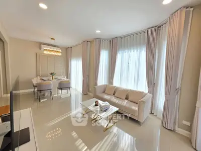 Elegant living room with modern decor and large windows, featuring a cozy sofa and stylish dining area.