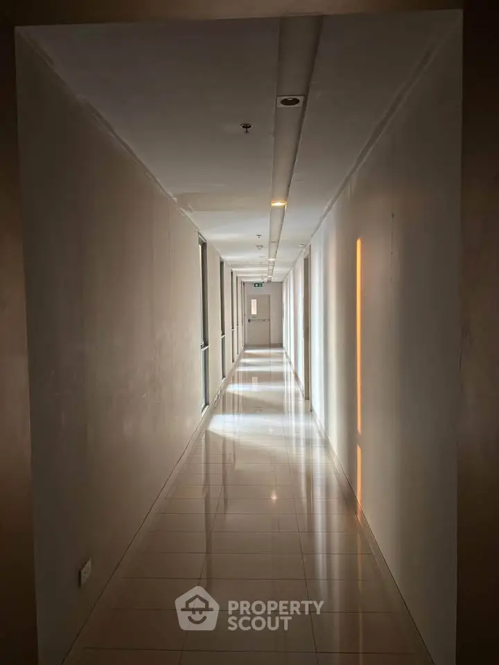 Sleek modern corridor with polished floors and ambient lighting in a contemporary building.