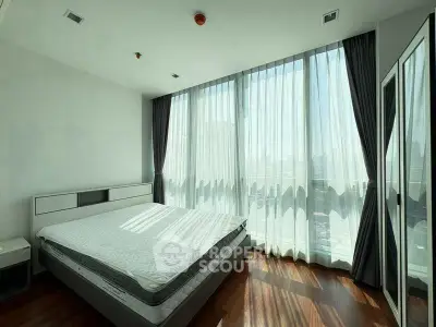 Spacious bedroom with floor-to-ceiling windows and elegant curtains