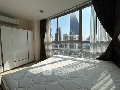 Spacious bedroom with large windows offering stunning city views in a modern apartment.